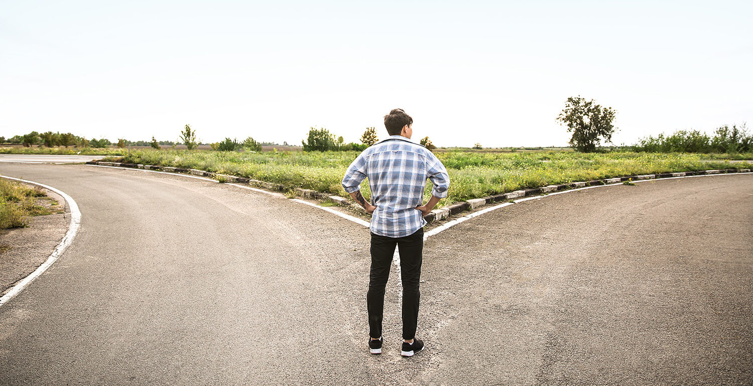 Man standing at a crossroads; Get a psychic or mediumship reading to find guidance from your spirit guides